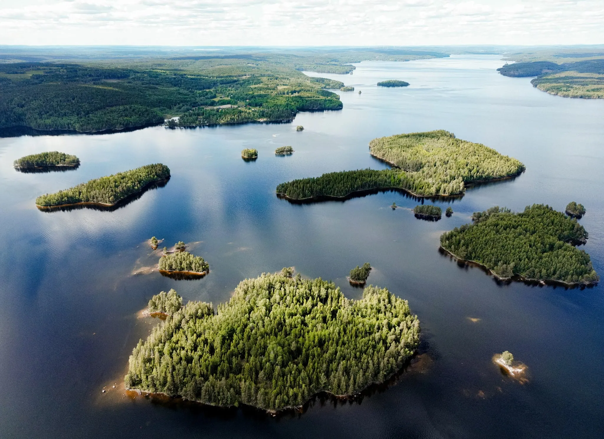Veduta aerea di isole boscose sparse su un ampio lago della Svezia occidentale