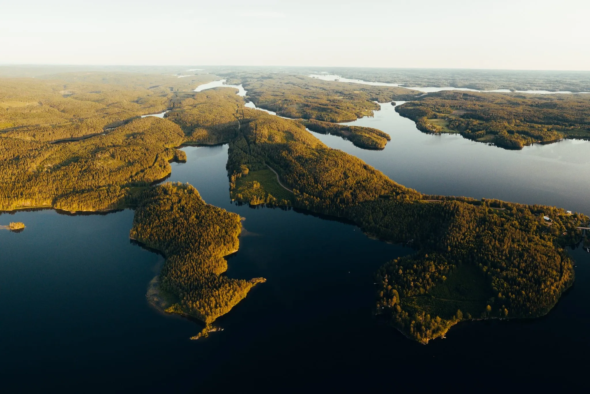 Isolotti boscosi su un lago calmo del Dalsland al tramonto